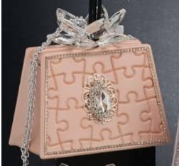 Grace Design borsa salmone con motivo puzzle, gemma e decoro petali in cristallo.
